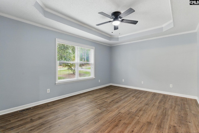 1149 Pond Branch Rd, Gilbert, SC 29054 - spare room with a tray ceiling, ornamental molding, dark wood-style floors, ceiling fan, and a textured ceiling