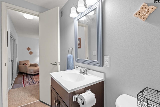 1908 Grays Inn Rd, Columbia, SC 29210 - bathroom featuring vanity, wood finished floors, toilet, and a textured wall