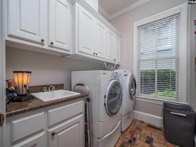 321 Lake Carolina Blvd, Columbia, SC 29229 - laundry room featuring washing machine and clothes dryer, cabinet space, crown molding, dark stone finish flooring, and baseboards