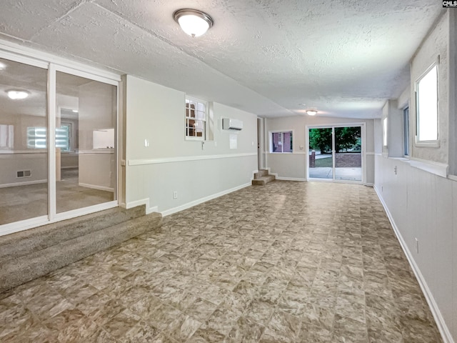 2540 Chatsworth Rd, Columbia, SC 29223 - empty room with a wall mounted air conditioner, baseboards, a textured ceiling, and tile patterned floors
