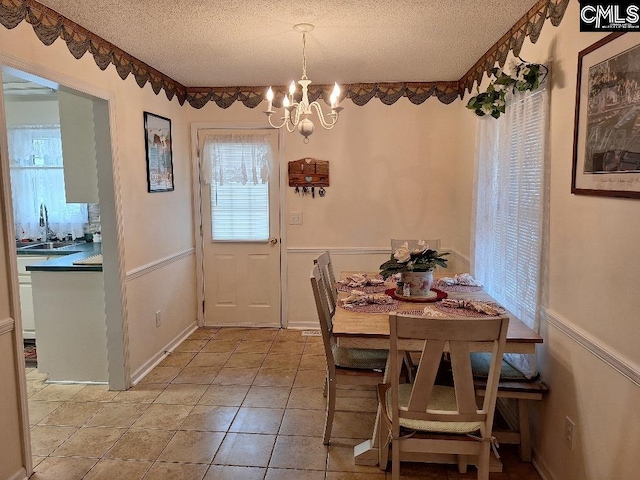 2279TICKLEHIL Tickle Hill Rd, Camden, SC 29020 - dining area featuring a textured ceiling, a chandelier, light tile patterned floors, and wainscoting