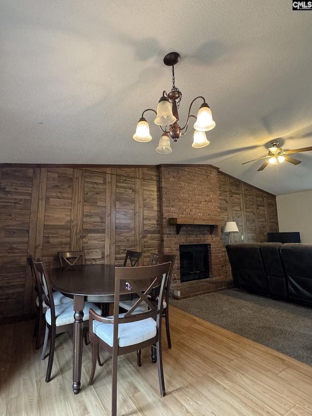 21 Forestgate Ct, Columbia, SC 29212 - dining space with a chandelier, vaulted ceiling, a ceiling fan, a fireplace, and light wood-type flooring