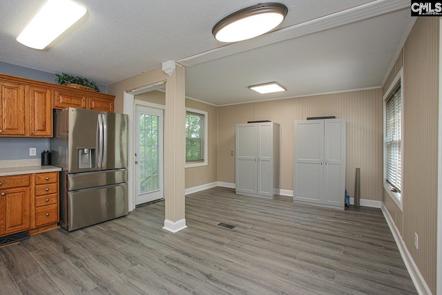 173 Rosewood Ln, Lexington, SC 29072 - kitchen with stainless steel fridge with ice dispenser, brown cabinets, light wood-style floors, light countertops, and ornamental molding