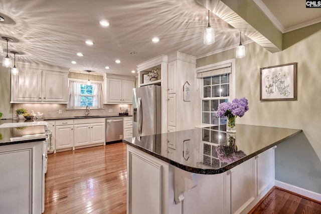 1108 Tarrytown Ln, West Columbia, SC 29170 - kitchen featuring appliances with stainless steel finishes, a sink, crown molding, white cabinets, and hardwood / wood-style floors