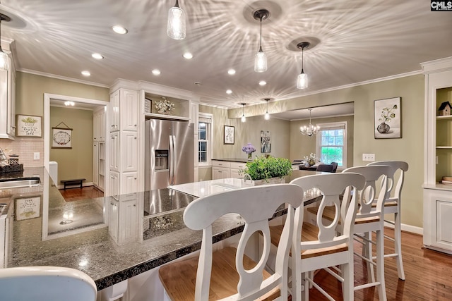 1108 Tarrytown Ln, West Columbia, SC 29170 - kitchen with stainless steel refrigerator with ice dispenser, ornamental molding, a sink, wood finished floors, and a breakfast bar