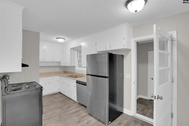 2136 Windale Dr, Columbia, SC 29223 - kitchen with appliances with stainless steel finishes, a textured ceiling, light wood-type flooring, light countertops, and white cabinetry