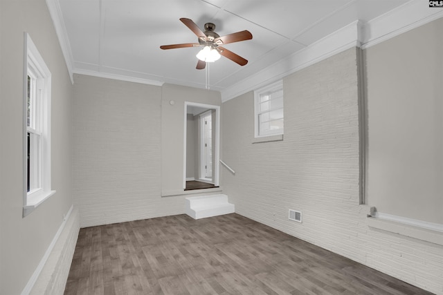 2136 Windale Dr, Columbia, SC 29223 - unfurnished room with plenty of natural light, wood finished floors, ceiling fan, ornamental molding, and brick wall