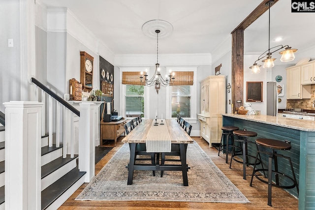 2909 Columbia Ave, Columbia, SC 29201 - dining space featuring wood finished floors, a chandelier, stairway, and crown molding