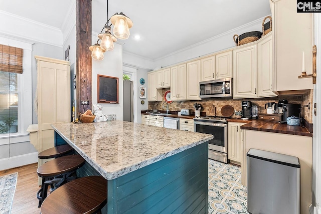 2909 Columbia Ave, Columbia, SC 29201 - kitchen featuring stainless steel appliances, backsplash, a breakfast bar, a peninsula, and ornamental molding