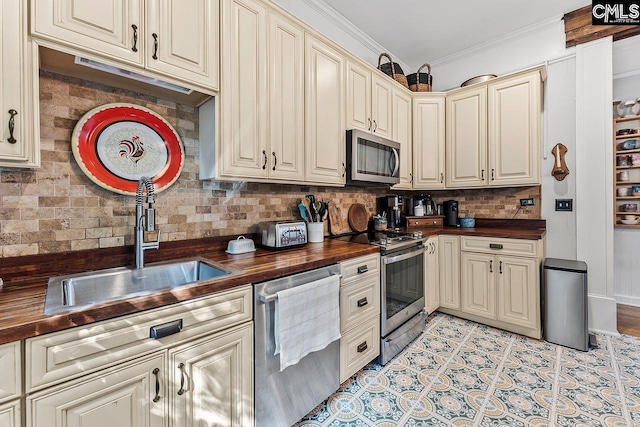 2909 Columbia Ave, Columbia, SC 29201 - kitchen with butcher block counters, stainless steel appliances, a sink, cream cabinetry, and decorative backsplash