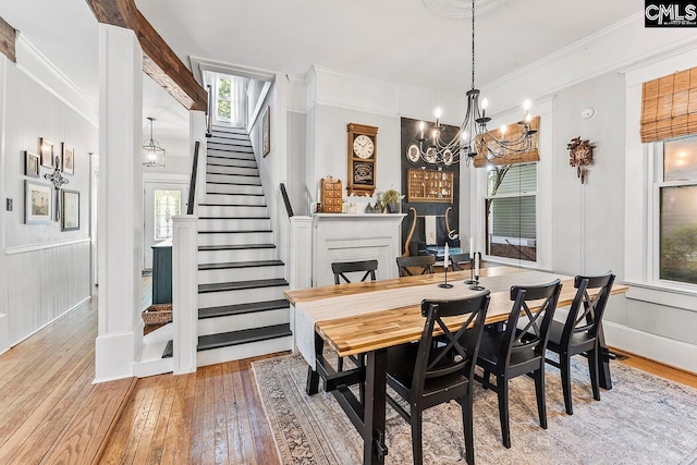 2909 Columbia Ave, Columbia, SC 29201 - dining area featuring hardwood / wood-style flooring, a chandelier, stairs, crown molding, and baseboards