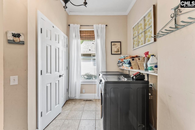 2909 Columbia Ave, Columbia, SC 29201 - laundry area featuring washing machine and dryer, healthy amount of natural light, crown molding, light tile patterned floors, and baseboards