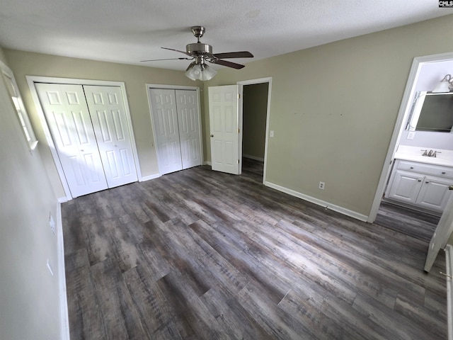 804 Dogwood St, Cayce, SC 29033 - unfurnished bedroom with two closets, dark wood-style flooring, baseboards, connected bathroom, and a ceiling fan