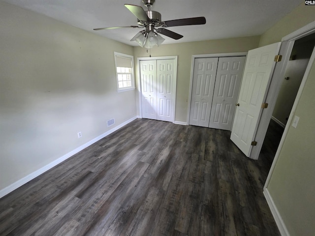 804 Dogwood St, Cayce, SC 29033 - unfurnished bedroom with two closets, dark wood finished floors, baseboards, and a ceiling fan