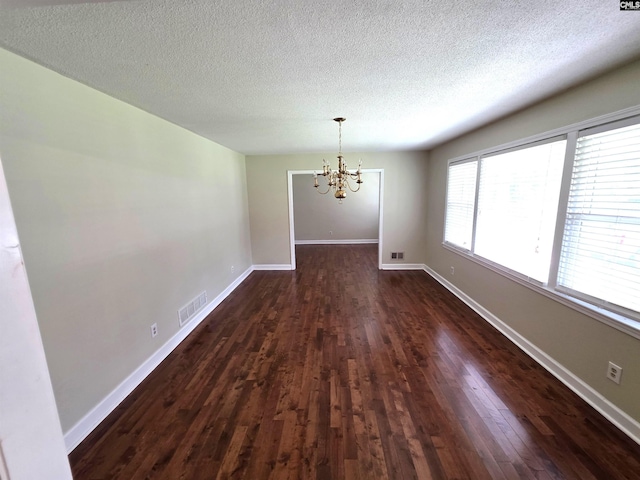 804 Dogwood St, Cayce, SC 29033 - unfurnished dining area featuring a chandelier, dark wood-type flooring, a textured ceiling, and baseboards