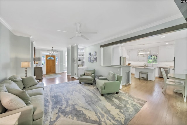315 Poindexter Ln, Lexington, SC 29072 - living room featuring a chandelier, crown molding, light wood finished floors, ceiling fan, and baseboards