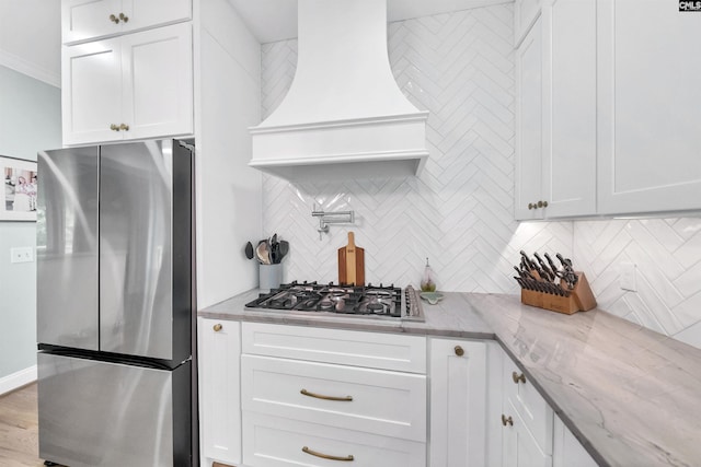 315 Poindexter Ln, Lexington, SC 29072 - kitchen featuring stainless steel appliances, custom range hood, decorative backsplash, white cabinets, and light stone counters