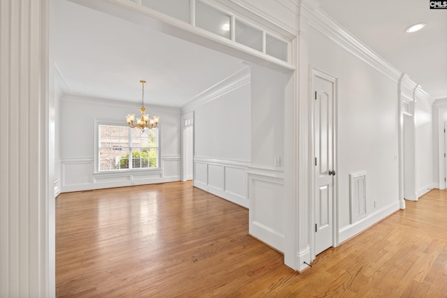 104 Eastshore Dr, Lexington, SC 29072 - unfurnished room featuring a chandelier, crown molding, a decorative wall, light wood-style floors, and wainscoting
