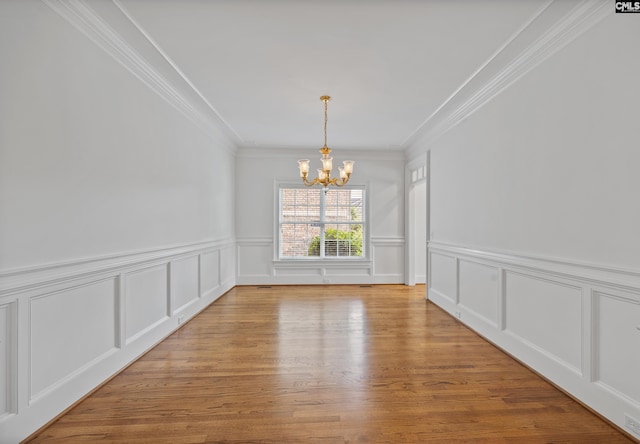 104 Eastshore Dr, Lexington, SC 29072 - unfurnished dining area with a chandelier, crown molding, a decorative wall, wainscoting, and light wood-style flooring