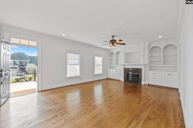 104 Eastshore Dr, Lexington, SC 29072 - unfurnished living room featuring ceiling fan, healthy amount of natural light, a tiled fireplace, light wood-style flooring, and ornamental molding