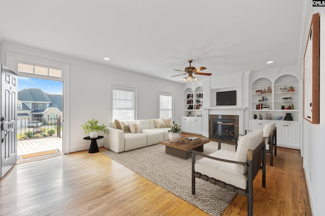 104 Eastshore Dr, Lexington, SC 29072 - living room featuring crown molding, a tiled fireplace, healthy amount of natural light, ceiling fan, and wood finished floors