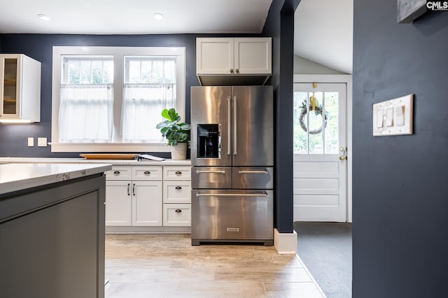 2808 River Dr, Columbia, SC 29201 - kitchen featuring high end fridge, white cabinets, vaulted ceiling, glass insert cabinets, and recessed lighting