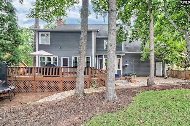 205 Weeping Cherry Ln, Columbia, SC 29212 - rear view of house featuring a trampoline, a wooden deck, and a chimney