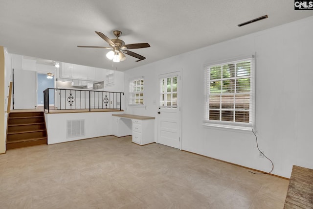 2915 Woodland Hls, Columbia, SC 29210 - unfurnished living room with ceiling fan, healthy amount of natural light, stairway, and light floors