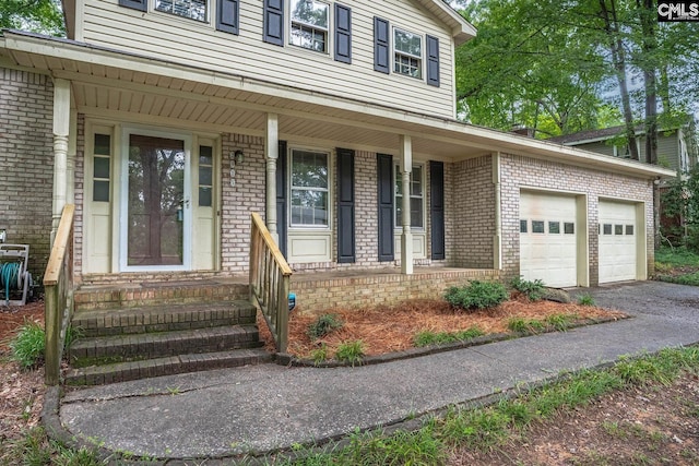 2915 Woodland Hls, Columbia, SC 29210 - property entrance featuring brick siding, covered porch, asphalt driveway, and an attached garage