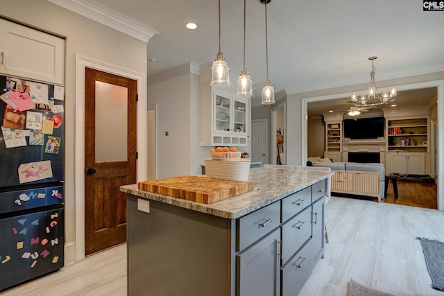108 Shallow Brook Dr, Columbia, SC 29223 - kitchen featuring freestanding refrigerator, a kitchen island, crown molding, white cabinets, and hanging light fixtures
