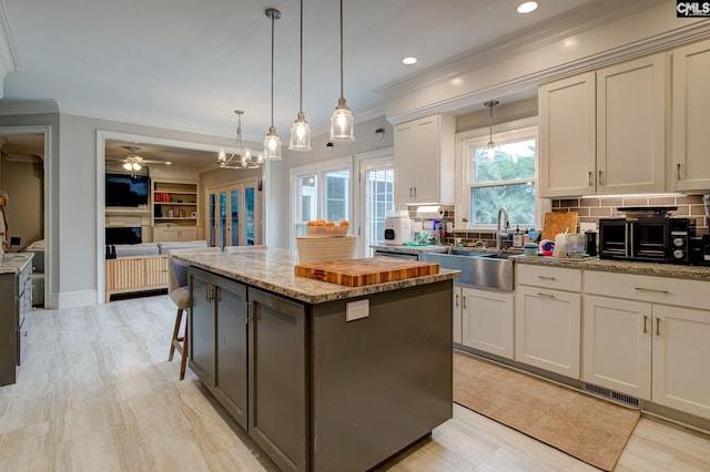 108 Shallow Brook Dr, Columbia, SC 29223 - kitchen with a sink, a center island, ceiling fan, backsplash, and crown molding