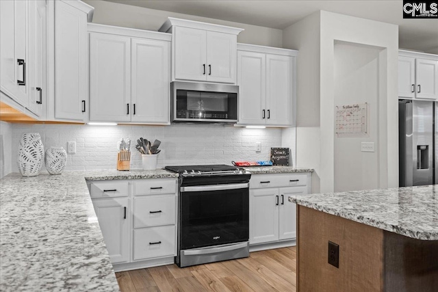 521 Fenwick Dr, Woodruff, SC 29388 - kitchen with appliances with stainless steel finishes, white cabinets, light wood-style floors, and light stone counters