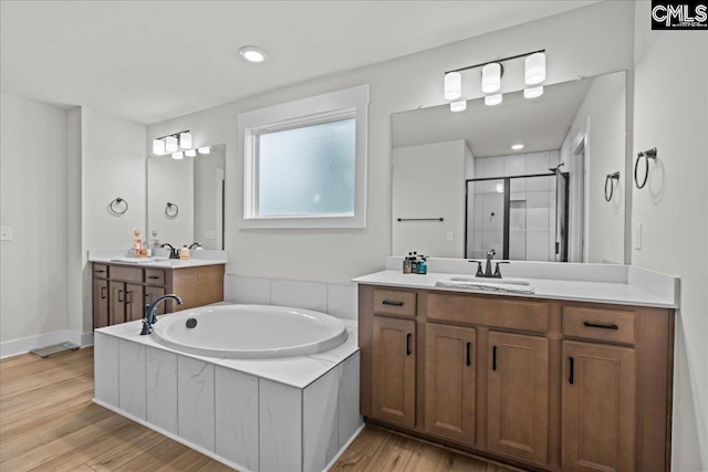521 Fenwick Dr, Woodruff, SC 29388 - bathroom featuring a bath, a shower stall, two vanities, and wood finished floors
