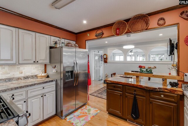 4661 Sylvan Dr, Columbia, SC 29206 - kitchen featuring stainless steel appliances, crown molding, white cabinetry, decorative backsplash, and light wood finished floors