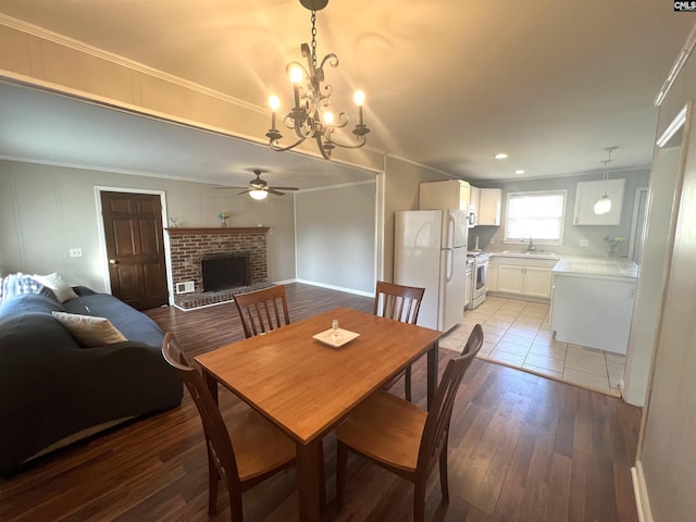 1432 Karlaney Ave, Cayce, SC 29033 - dining space featuring a ceiling fan, ornamental molding, light wood finished floors, a brick fireplace, and a chandelier