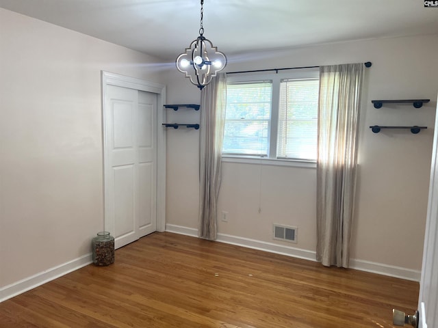 1432 Karlaney Ave, Cayce, SC 29033 - unfurnished dining area with a chandelier, wood finished floors, and baseboards