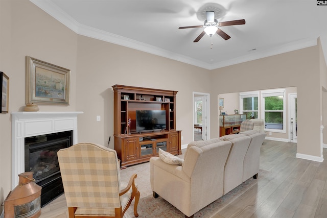383 Summersweet Ct, Blythewood, SC 29016 - living room featuring a ceiling fan, ornamental molding, light wood-style floors, a glass covered fireplace, and baseboards