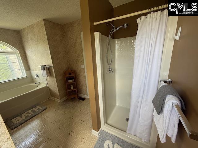 12 Beech Branch Ct, Irmo, SC 29063 - full bath with a garden tub, a shower stall, a textured ceiling, and baseboards