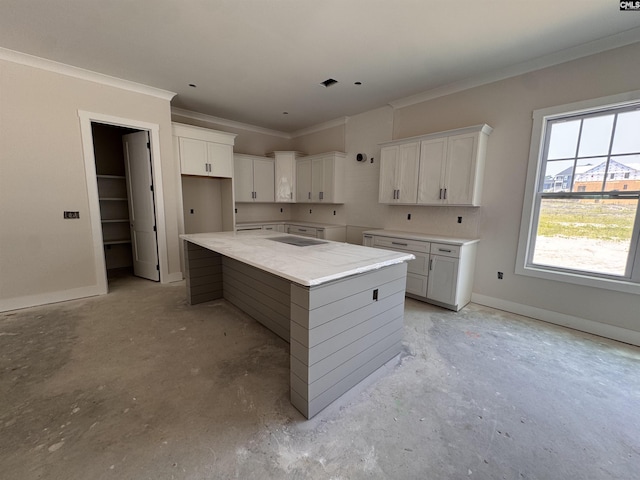 147 Harborside Cir, Columbia, SC 29229 - kitchen featuring ornamental molding, a kitchen island, concrete flooring, white cabinetry, and baseboards