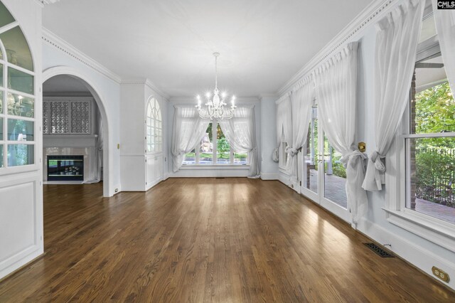 415 Pine St, Camden, SC 29020 - unfurnished dining area featuring a chandelier, a tiled fireplace, dark wood-style flooring, crown molding, and arched walkways
