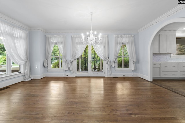 415 Pine St, Camden, SC 29020 - unfurnished dining area with a chandelier, arched walkways, dark wood finished floors, baseboards, and crown molding