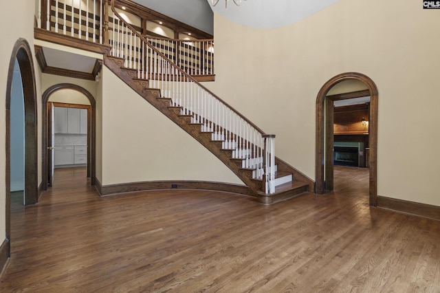 415 Pine St, Camden, SC 29020 - entryway featuring arched walkways, baseboards, wood finished floors, a fireplace, and stairs