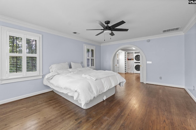 415 Pine St, Camden, SC 29020 - bedroom with stacked washer and clothes dryer, wood finished floors, baseboards, crown molding, and arched walkways