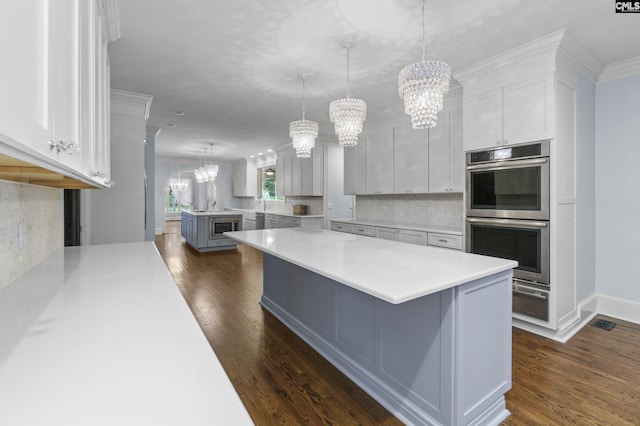 415 Pine St, Camden, SC 29020 - kitchen with double oven, a chandelier, dark wood-style flooring, and ornamental molding