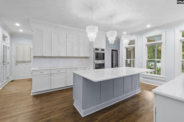 415 Pine St, Camden, SC 29020 - kitchen with double oven, a chandelier, crown molding, light countertops, and dark wood-style flooring
