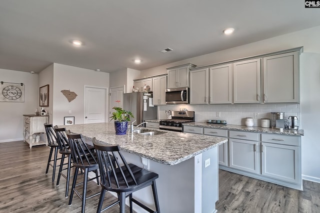 837 Marigold Ln, Lexington, SC 29072 - kitchen featuring appliances with stainless steel finishes, a sink, gray cabinetry, an island with sink, and a kitchen bar