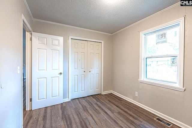 711 Parrish Dr, Mullins, SC 29574 - unfurnished bedroom with dark wood-type flooring, crown molding, a textured ceiling, a closet, and baseboards