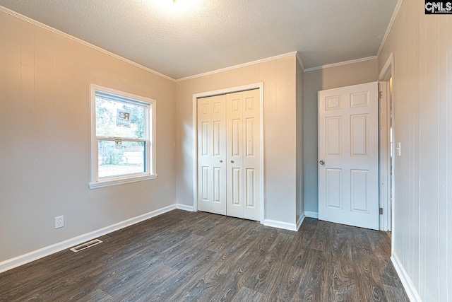 711 Parrish Dr, Mullins, SC 29574 - unfurnished bedroom with dark wood-style flooring, crown molding, a textured ceiling, a closet, and baseboards