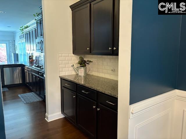 288 Links Crossing Dr, Blythewood, SC 29016 - kitchen with appliances with stainless steel finishes, dark stone counters, tasteful backsplash, dark wood-type flooring, and ornamental molding