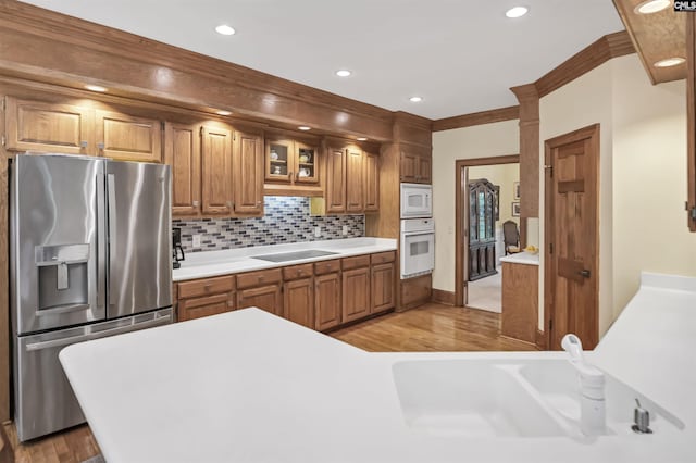 832 Longtown Rd, Blythewood, SC 29016 - kitchen with white appliances, light countertops, light wood-type flooring, brown cabinetry, and tasteful backsplash